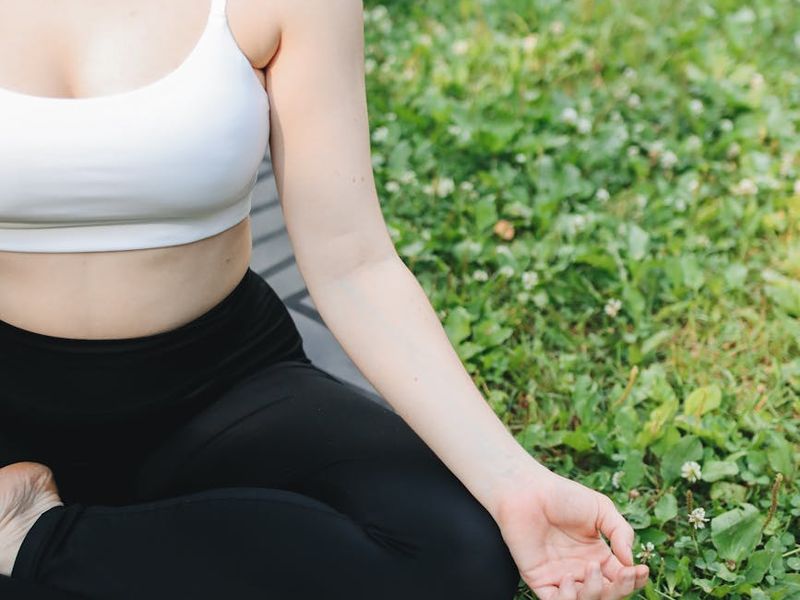 Person sitting calmly in a well-lit room, focused on breathing.