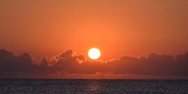 View of a calm sea at sunrise.